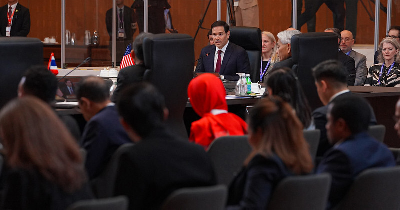 Secretary of State Marco Rubio speaking to ASEAN leaders seated at a large conference table with flags.