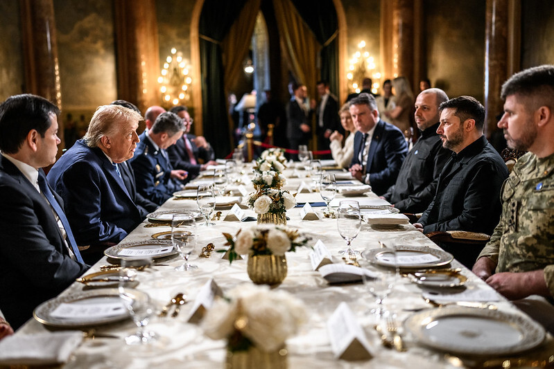 President Trump and Secretary Rubio sit across from President Zelensky at a table at the Mar-a-Lago Club. 
