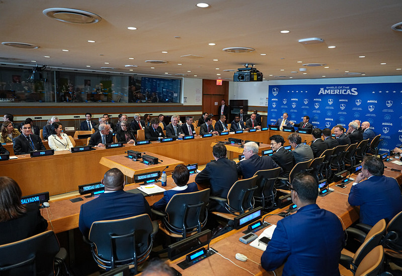 Secretary Rubio sits at the head of a very large conference table around which dignitaries are seated. 