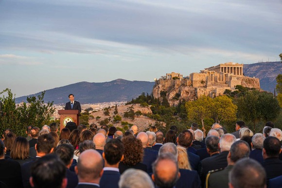 Secretary Rubio speaking at a lectern in front of the Acropolis in Greece.