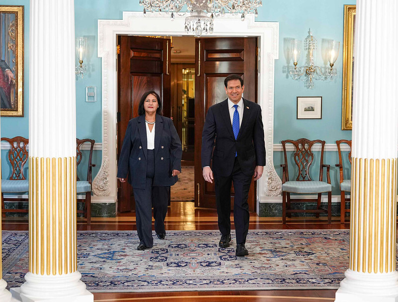 Secretary Rubio and Dinorah Figuera of Venezuela enter a reception room in the Department of State walking side by side.