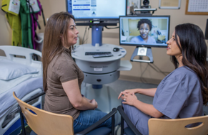 Photograph of a patient and a medical provider talking with another medical provider on a video chat