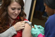 woman getting flu shot in upper arm 