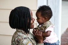 woman in uniform holding baby