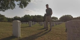 man standing in veteran cemetery