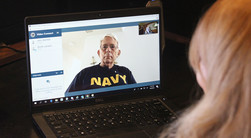 man on laptop screen wearing navy shirt