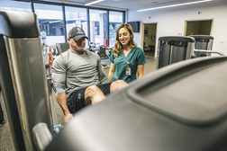 man working out as female clinician assists