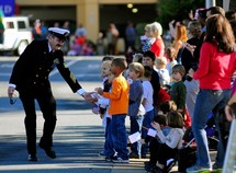 man in uniform shaking hands with children