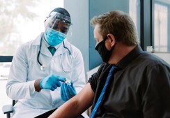 male patient and male caregiver providing immunization
