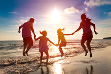 family jumping for joy on beach
