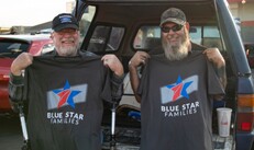 two men holding blue star families tshirts