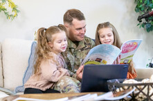 man in uniform reading to child