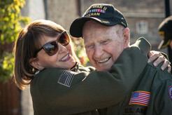 woman hugging elderly military veteran