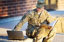 uniformed military service man using laptop for schoolwork