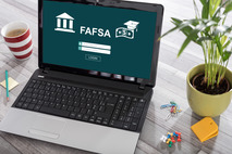laptop with an illustration of fafsa on the screen
