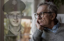man staring out window reflecting on his military service