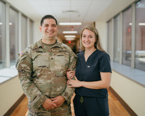 Soldier in uniform and wife wearing medical scrubs smiling