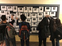 Children looking at photos along a wall. 