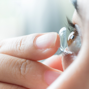Person putting contact lens in their eye.