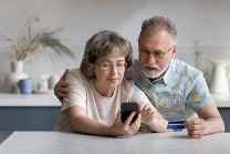 An older couple looking at smartphone together.