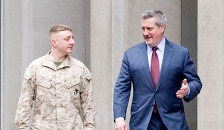 Two men walking and talking, one in military uniform.