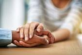 Two people holding hands showing compassion.