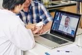 Couple using a laptop for a tele-health appointment.