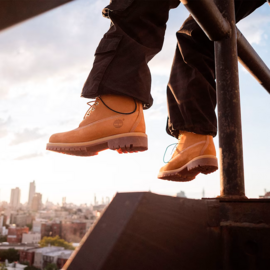 Person wearing boots with their legs dangling off seated position.