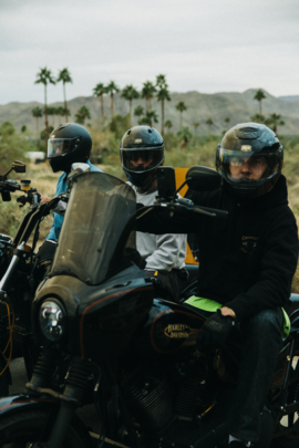 Three men on motorcycles wearing helmets.