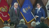 Two men standing on a stage having a discussion.