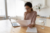 Woman reviewing paperwork with serious look on her face.