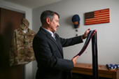 Man in business suit putting on a tie.