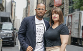 Man and woman smiling along a city street.