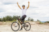 Man with prosthetic leg riding a bicycle.