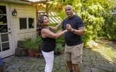 Husband and wife standing together in a ballroom dance pose.