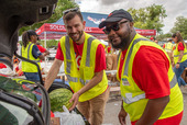 Two men loading a vehicle with food donations.