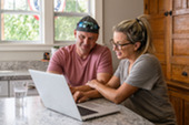 Marine Corps veteran and his wife sitting and working on a laptop.