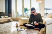 Woman sitting in living room, managing her finances.