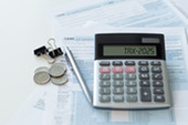 Calculator and tax forms for filing taxes.