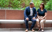 Man and woman sitting next to each other on a park bench.