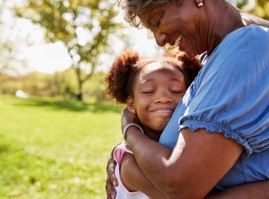 Granddaughter hugging grandmother in park