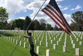 Young boy holding the U.S. flag in a VA national cemetery