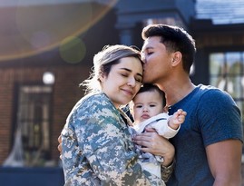 Service member hugs her child and husband