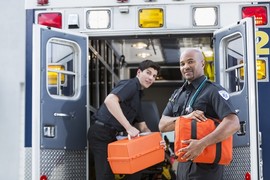 Veteran EMTs loading equipment into an ambulance