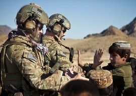 Service members receive high fives from children in Farah province, Afghanistan
