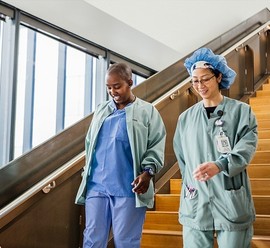 Two nurses walking around a VA medical center