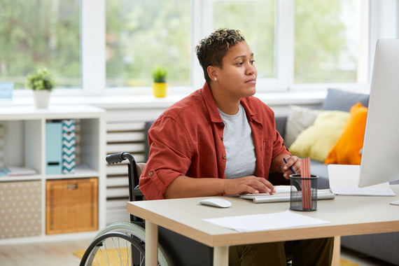 Woman in wheelchair working at a computer 