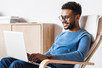 Man sitting in a chair looking at laptop computer.