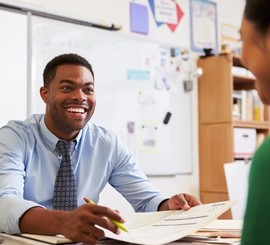 Teacher smiling at his students in public school