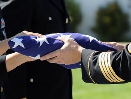 Military flag presentation ceremony at a Veteran's memorial